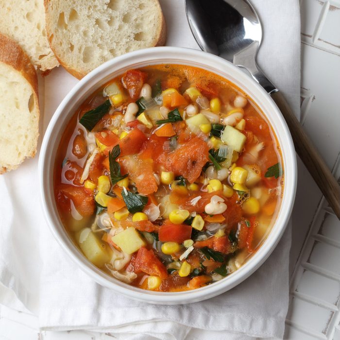 Seasonal vegetable soup with potatoes, carrots, onions, garlic, white beans, corn, tomatoes and parsley