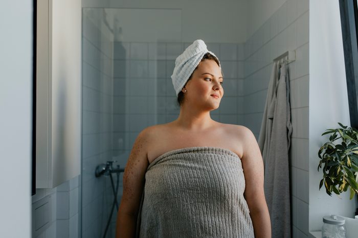 Portrait of a Happy plus size Woman Standing in the Bathroom after a Relaxing Shower