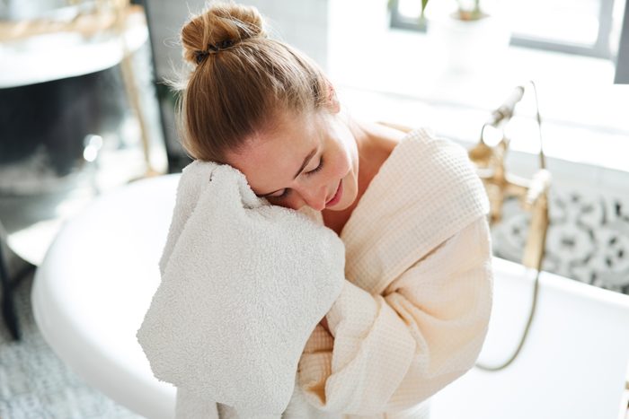 Woman wipes face with a towel after taking a bath
