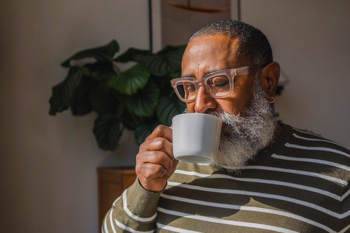 Senior hipster man drinking coffee in cup at home