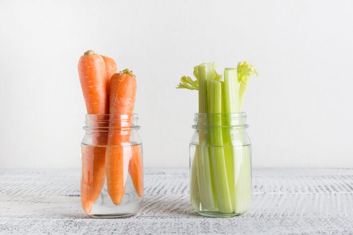 Fresh carrot and celery in mason jar with water