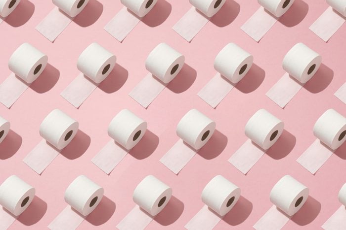 repeating pattern of rolls of toilet paper on pink background