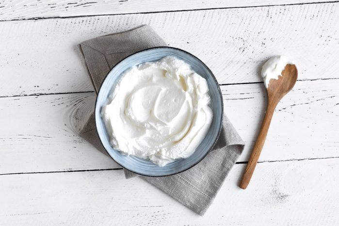 bowl of plain greek yogurt in a bowl with a wooden spoon