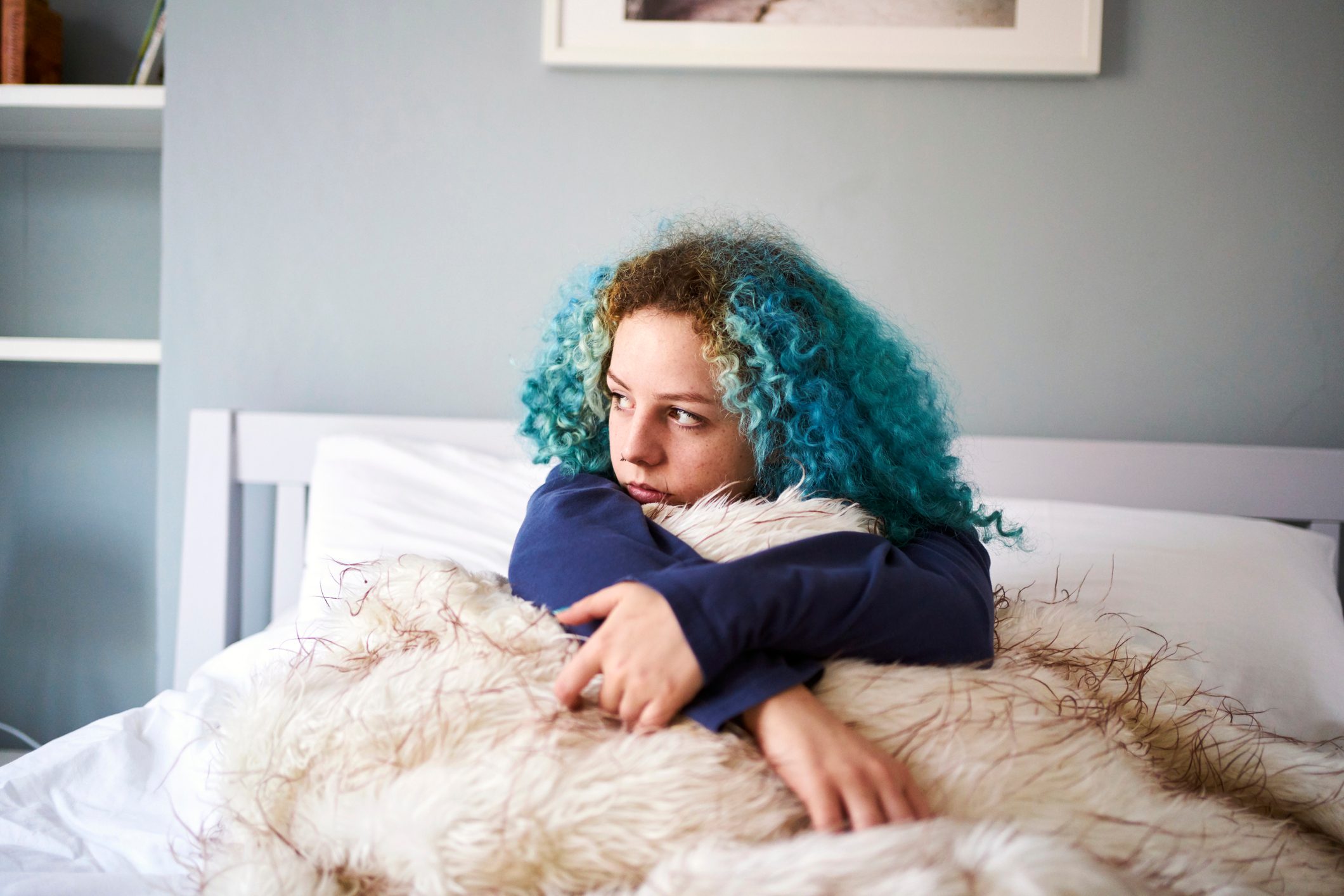 Young woman looking sad depressed and alone in bed