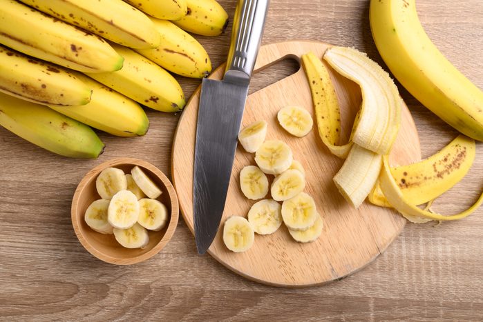 Sliced ripe banana fruit on wooden cutting board