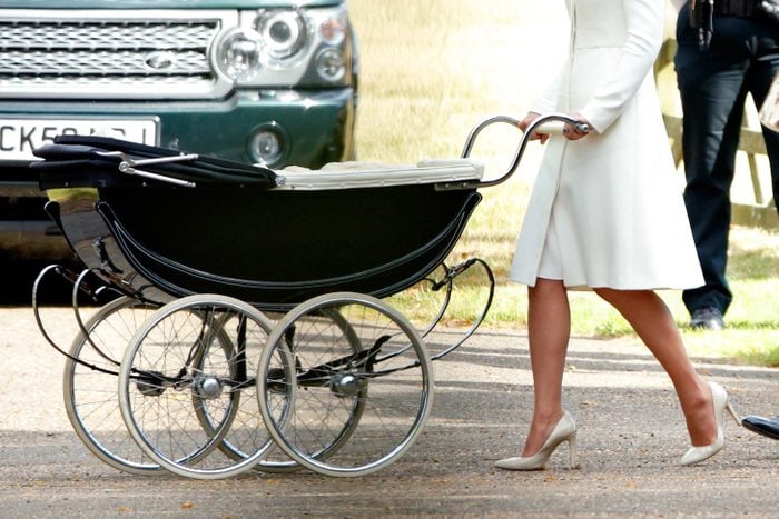 Kate Middleton pushing a baby stroller or buggy in white high heels