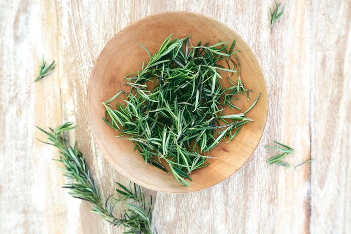 Top View Of Fresh Rosemary In Bowl On Wooden Table