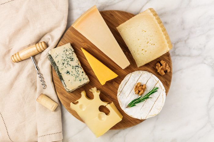 Selection of cheeses with corkscrew, cork, and copyspace
