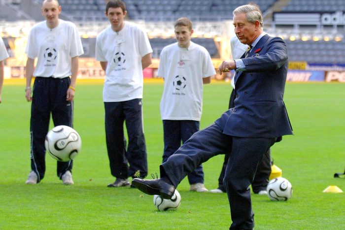 King Charles kicking a football or American soccer ball