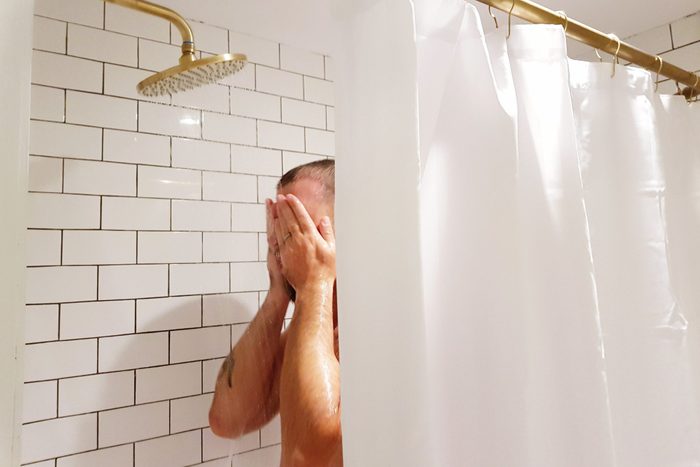 Man Taking Shower In Bathroom