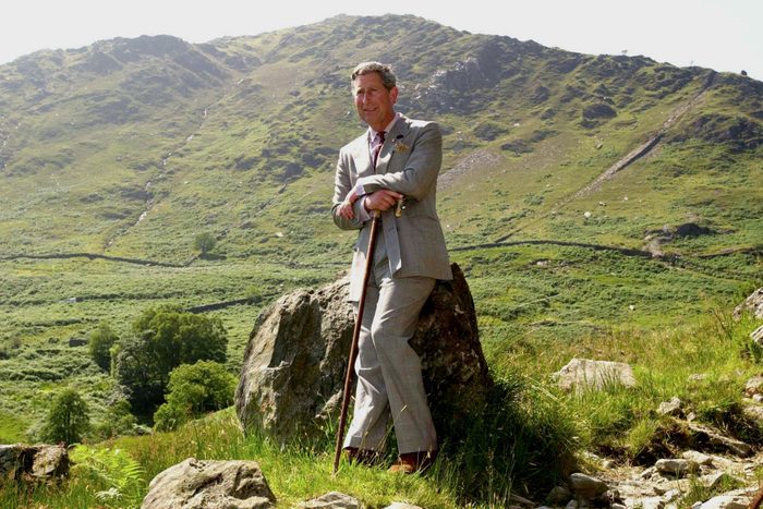 Britain's Prince Charles holding a can while leaning against a rock during a visit to the Hafod y Llan estate