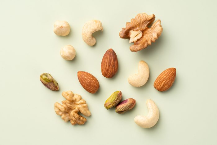 Mixed Nuts Assortment Include Hazelnut, Pistachio, Walnut, Almond and Cashew Nuts Arranged on Light Green Colored Background Directly Above View