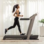 Young woman running on a treadmill indoors