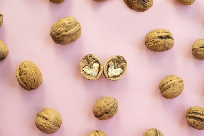 Walnuts heart shaped on pink background