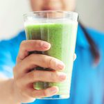 Midsection Of Woman Holding a green Smoothie
