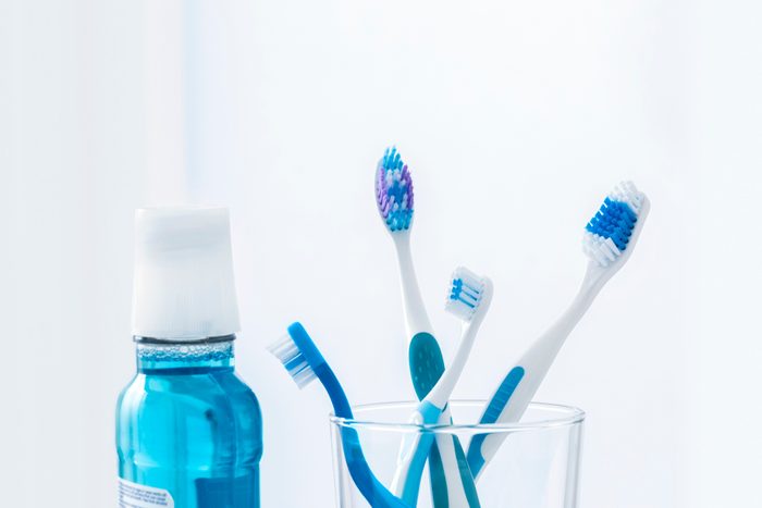 Toothbrushes in glass with mouthwash