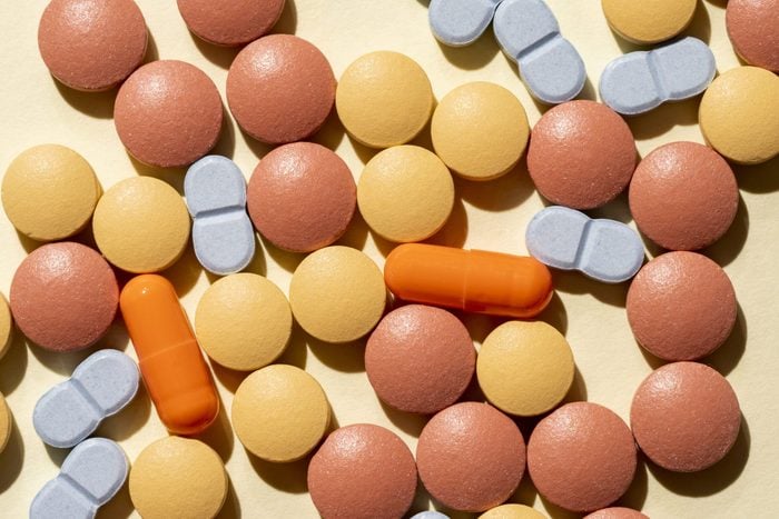 Multi Colored And Multi Shape Pills On A Yellow Colored Background