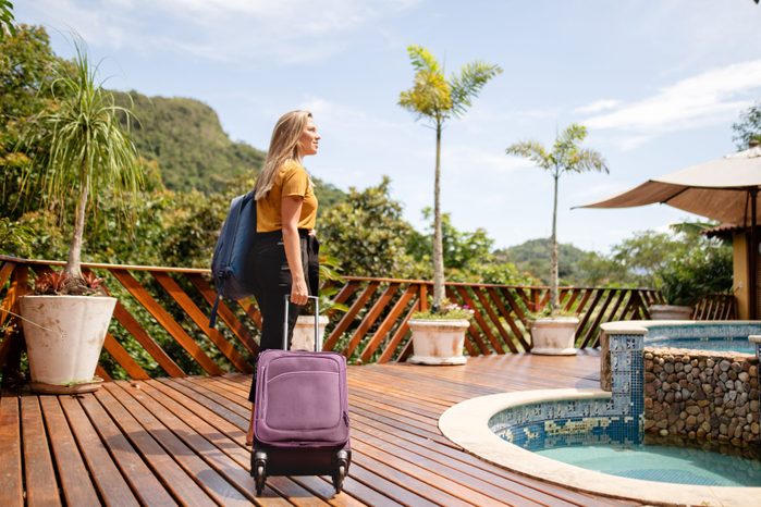Young woman arriving at a tropical resort for her vacation