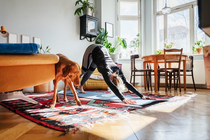 Single Mom Doing Yoga In Living Room At Home