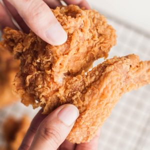 High angle view of Southeast Asian person holding fried chicken wings