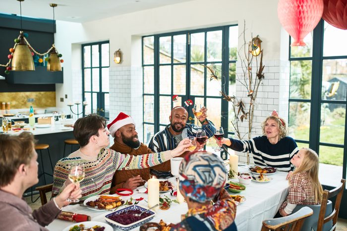 Cheerful multi ethnic family raising glasses at Christmas dinner