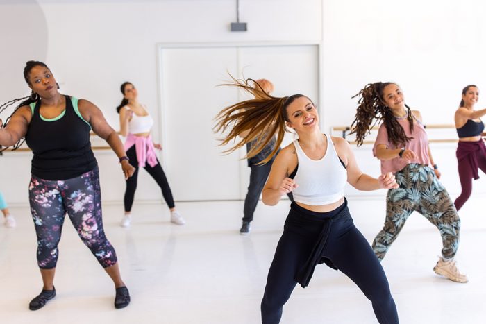 Multiracial people doing zumba dance in fitness studio