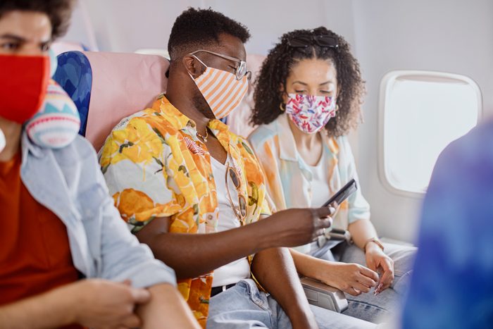 Young couple wearing protective face masks during flight