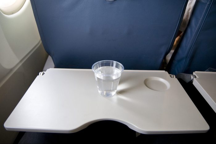 plastic cup of water on an airplane tray