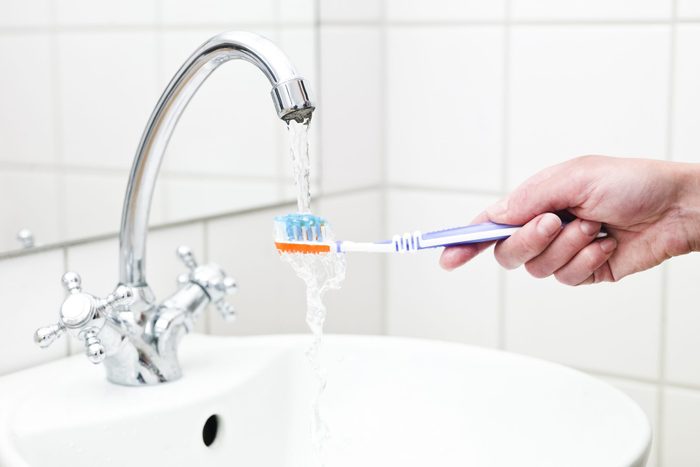 Human holding toothbrush