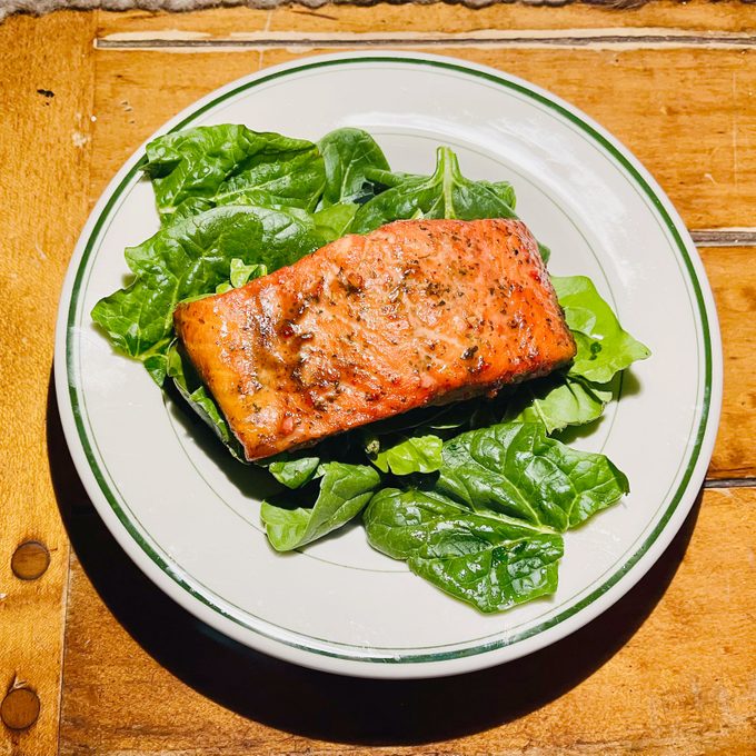 salmon over greens on a plate