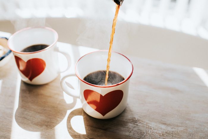 pouring coffee into a mug with a heart on it