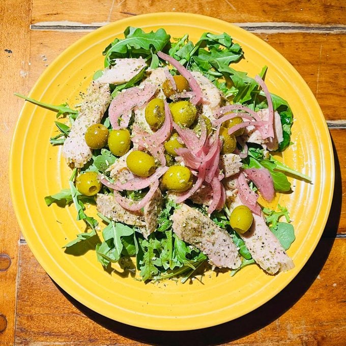 the author's variation on a Nicoise salad on a yellow plate