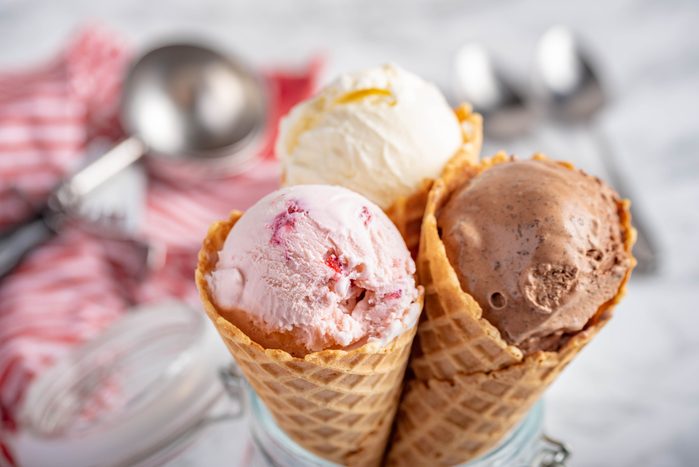 клубничное, ванильное, шоколадное мороженое с вафельным рожком на фоне мраморного камня