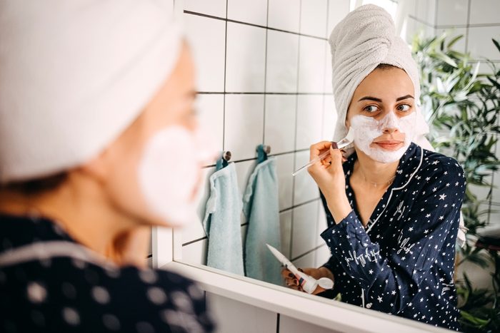 Woman applying a face mask in the bathroom