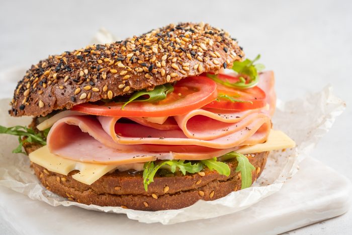 bagel filled with ham, cream cheese and tomato