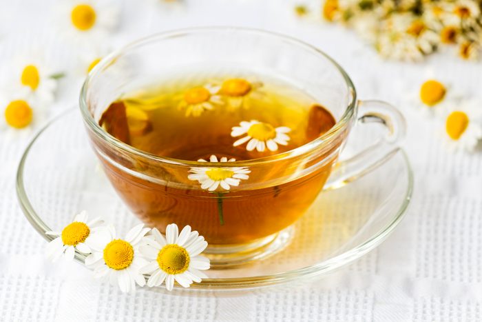 Cup of camomile tea with camomile flowers