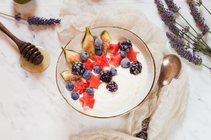Bowl of Greek yoghurt with fig, watermelon, frozen berries and lavender honey
