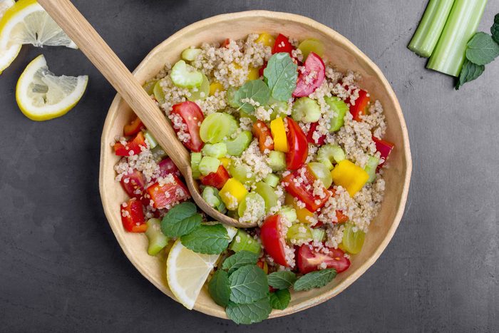 top view of a healthy quinoa veggie bowl with a wooden spoon