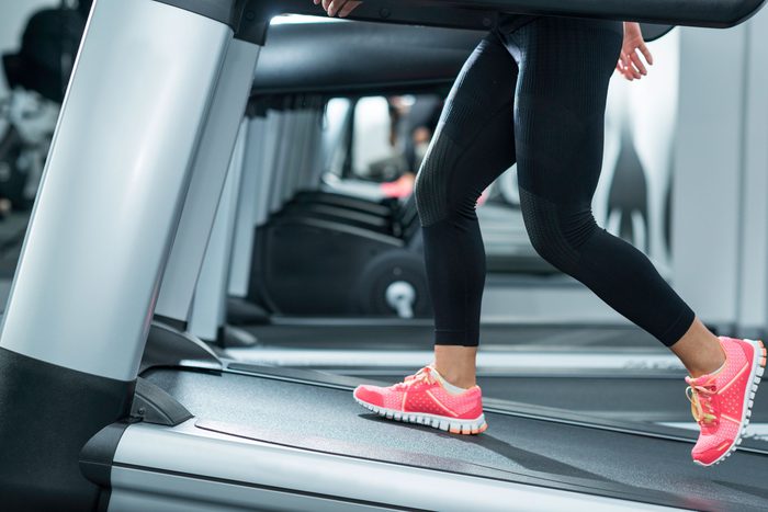 Woman using incline treadmill in modern updated gym