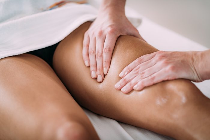 Cropped Hands Of Massage Therapist Massaging Female Customer In Spa