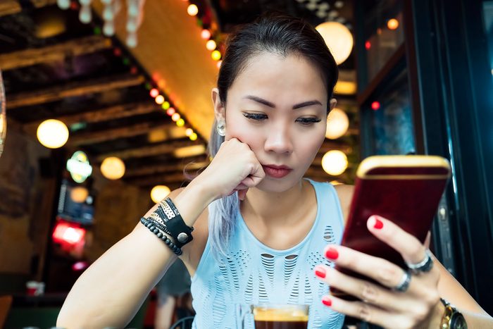Asian woman having bad news on mobile phone