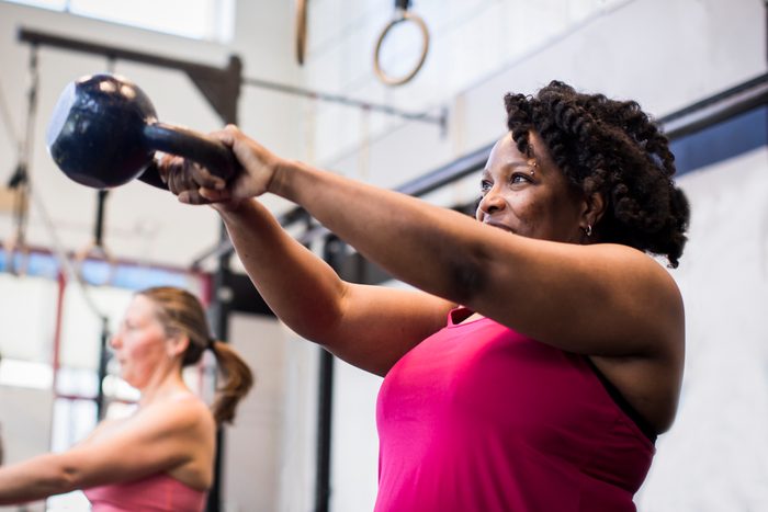 mature women exercising with kettlebell in the gym.