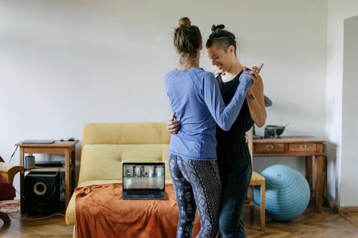 A young couple learning the tango with an online class at home together.
