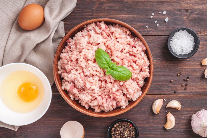 Raw minced meat in bowl on wooden table