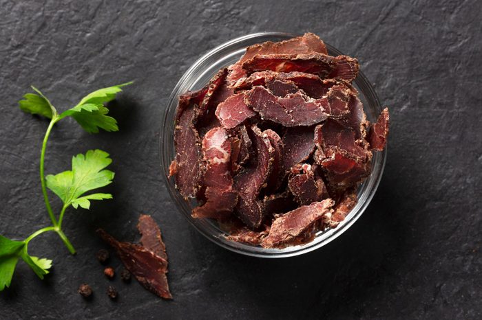 Bowl with jerky meat on a dark background