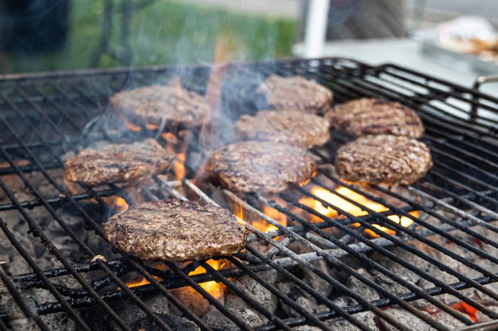 Close-up of hamburgers cooking on charcoal grill