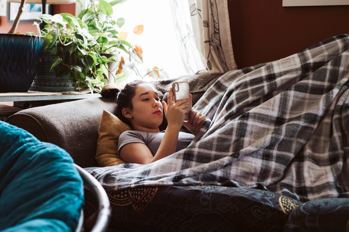 Teenager on couch on phone