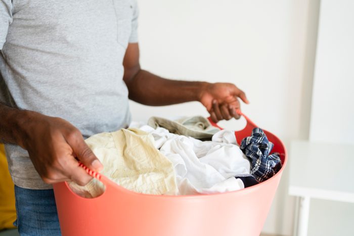 Man holding laundry basket at home