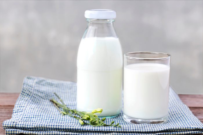 vaso de leche y botella de leche en la mesa de madera/ presión arterial alta