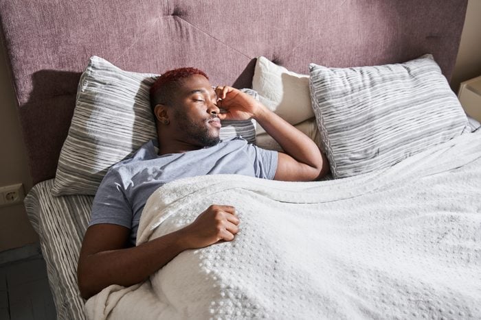 Man sleeping on comfortable pillow in bed at home at the morning
